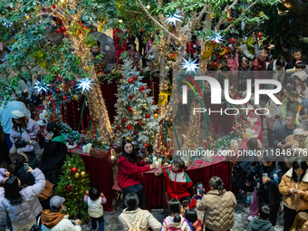 Visitors look at a Christmas tree installation at the Halo Shopping Park in Chongqing, China, on December 8, 2024. (