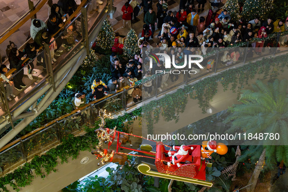 Visitors watch Santa Claus' flying sleigh ride at Halo Shopping Park in Chongqing, China, on December 8, 2024. 