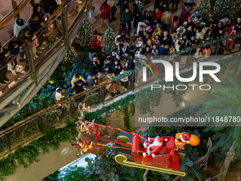 Visitors watch Santa Claus' flying sleigh ride at Halo Shopping Park in Chongqing, China, on December 8, 2024. (