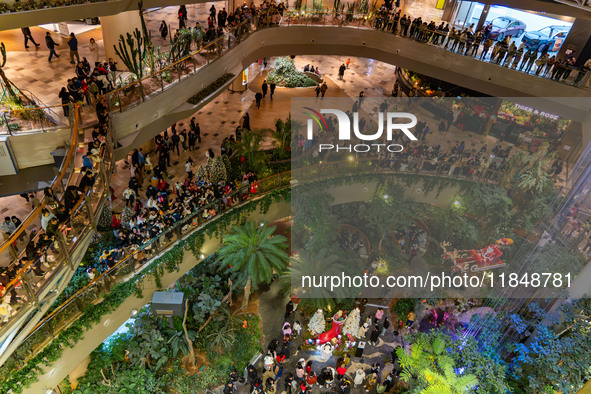 Visitors watch Santa Claus' flying sleigh ride at Halo Shopping Park in Chongqing, China, on December 8, 2024. 