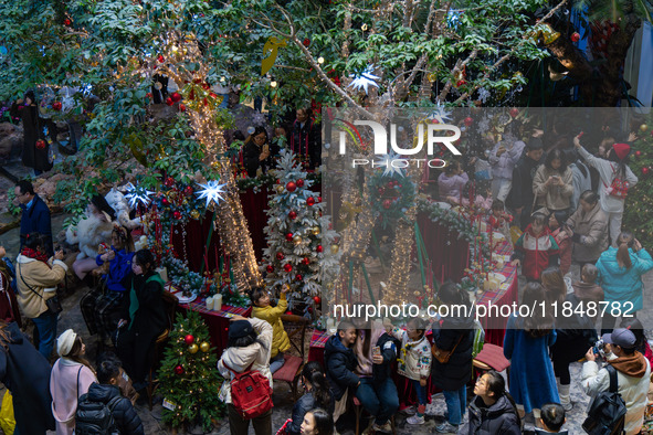 Visitors look at a Christmas tree installation at the Halo Shopping Park in Chongqing, China, on December 8, 2024. 