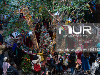 Visitors look at a Christmas tree installation at the Halo Shopping Park in Chongqing, China, on December 8, 2024. (