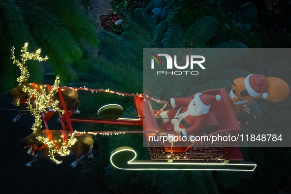 Visitors watch Santa Claus' flying sleigh ride at Halo Shopping Park in Chongqing, China, on December 8, 2024. 