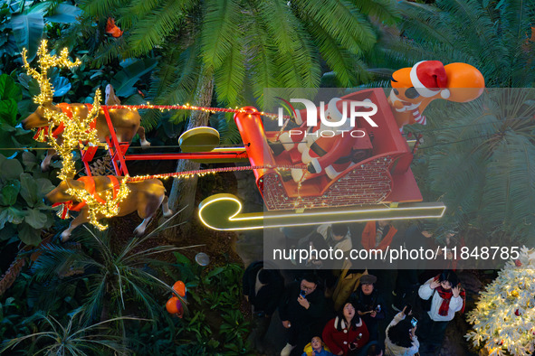 Visitors watch Santa Claus' flying sleigh ride at Halo Shopping Park in Chongqing, China, on December 8, 2024. 