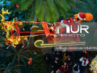 Visitors watch Santa Claus' flying sleigh ride at Halo Shopping Park in Chongqing, China, on December 8, 2024. (