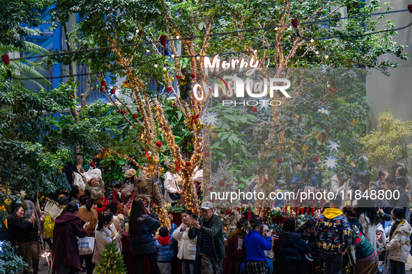 Visitors look at a Christmas tree installation at the Halo Shopping Park in Chongqing, China, on December 8, 2024. 