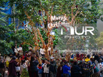 Visitors look at a Christmas tree installation at the Halo Shopping Park in Chongqing, China, on December 8, 2024. (