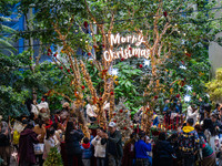 Visitors look at a Christmas tree installation at the Halo Shopping Park in Chongqing, China, on December 8, 2024. (