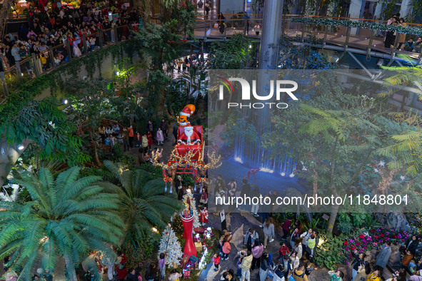 Visitors look at a Santa Claus installation at the Halo Shopping Park in Chongqing, China, on December 8, 2024. 