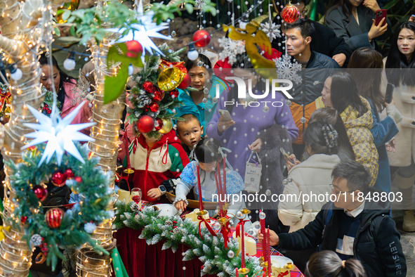 Visitors look at a Christmas tree installation at the Halo Shopping Park in Chongqing, China, on December 8, 2024. 