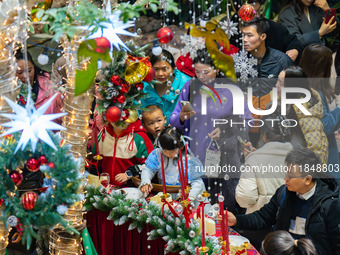 Visitors look at a Christmas tree installation at the Halo Shopping Park in Chongqing, China, on December 8, 2024. (