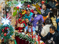 Visitors look at a Christmas tree installation at the Halo Shopping Park in Chongqing, China, on December 8, 2024. (