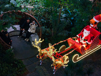 Visitors watch Santa Claus' flying sleigh ride at Halo Shopping Park in Chongqing, China, on December 8, 2024. (