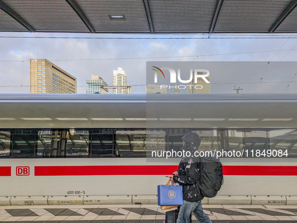 In Frankfurt am Main Central Station in Hesse, Germany, on January 1, 2024, at 9:00 in the morning, a traveler with luggage and shopping bag...