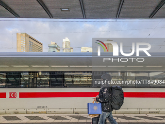 In Frankfurt am Main Central Station in Hesse, Germany, on January 1, 2024, at 9:00 in the morning, a traveler with luggage and shopping bag...