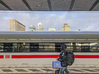 In Frankfurt am Main Central Station in Hesse, Germany, on January 1, 2024, at 9:00 in the morning, a traveler with luggage and shopping bag...