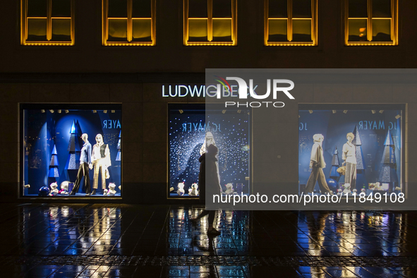 On a rainy evening in Munich, Bavaria, Germany, on December 8, 2024, during the Christmas season, the streets come alive with the glow of fe...