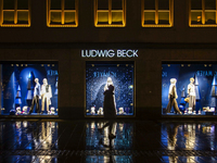 On a rainy evening in Munich, Bavaria, Germany, on December 8, 2024, during the Christmas season, the streets come alive with the glow of fe...