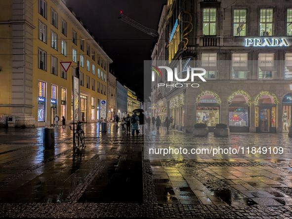 On a rainy evening in Munich, Bavaria, Germany, on December 8, 2024, during the Christmas season, the streets come alive with the glow of fe...