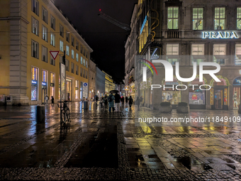 On a rainy evening in Munich, Bavaria, Germany, on December 8, 2024, during the Christmas season, the streets come alive with the glow of fe...