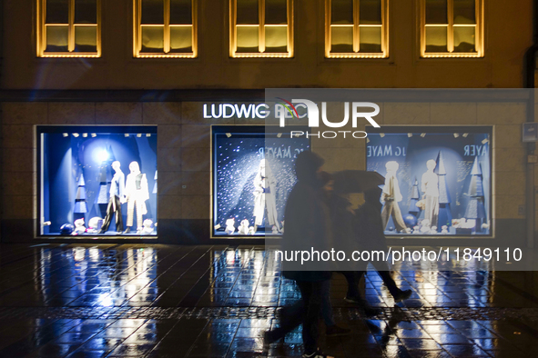 On a rainy evening in Munich, Bavaria, Germany, on December 8, 2024, during the Christmas season, the streets come alive with the glow of fe...