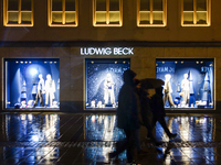 On a rainy evening in Munich, Bavaria, Germany, on December 8, 2024, during the Christmas season, the streets come alive with the glow of fe...