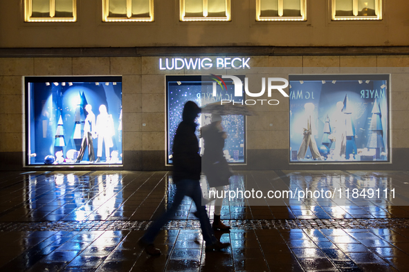 On a rainy evening in Munich, Bavaria, Germany, on December 8, 2024, during the Christmas season, the streets come alive with the glow of fe...