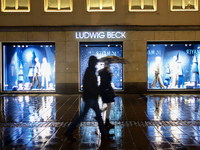 On a rainy evening in Munich, Bavaria, Germany, on December 8, 2024, during the Christmas season, the streets come alive with the glow of fe...