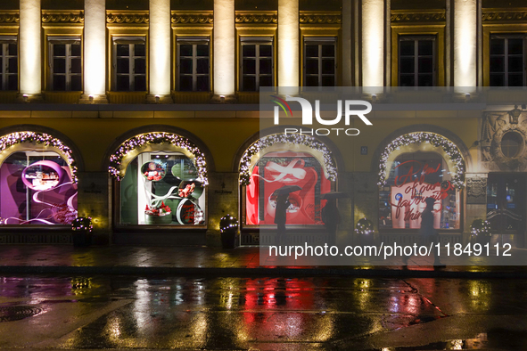 On a rainy evening in Munich, Bavaria, Germany, on December 8, 2024, during the Christmas season, the streets come alive with the glow of fe...