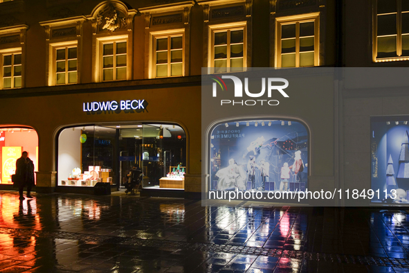 On a rainy evening in Munich, Bavaria, Germany, on December 8, 2024, during the Christmas season, the streets come alive with the glow of fe...