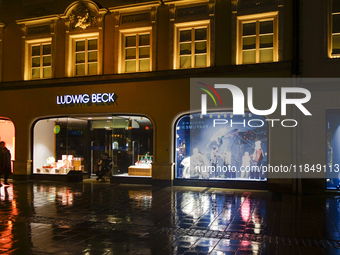 On a rainy evening in Munich, Bavaria, Germany, on December 8, 2024, during the Christmas season, the streets come alive with the glow of fe...