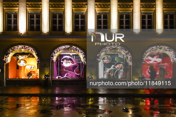 On a rainy evening in Munich, Bavaria, Germany, on December 8, 2024, during the Christmas season, the streets come alive with the glow of fe...