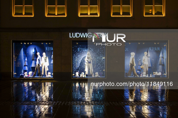 On a rainy evening in Munich, Bavaria, Germany, on December 8, 2024, during the Christmas season, the streets come alive with the glow of fe...