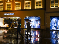 On a rainy evening in Munich, Bavaria, Germany, on December 8, 2024, during the Christmas season, the streets come alive with the glow of fe...