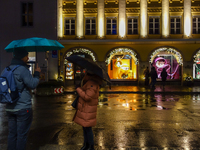 On a rainy evening in Munich, Bavaria, Germany, on December 8, 2024, during the Christmas season, the streets come alive with the glow of fe...