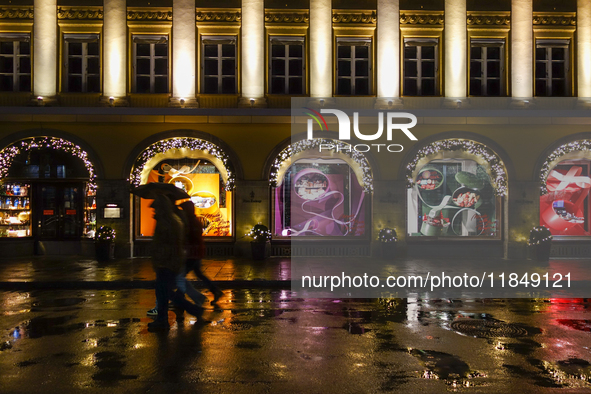 On a rainy evening in Munich, Bavaria, Germany, on December 8, 2024, during the Christmas season, the streets come alive with the glow of fe...