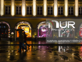 On a rainy evening in Munich, Bavaria, Germany, on December 8, 2024, during the Christmas season, the streets come alive with the glow of fe...