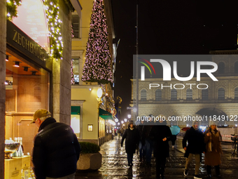 On a rainy evening in Munich, Bavaria, Germany, on December 8, 2024, during the Christmas season, the streets come alive with the glow of fe...