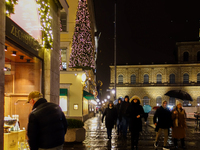 On a rainy evening in Munich, Bavaria, Germany, on December 8, 2024, during the Christmas season, the streets come alive with the glow of fe...