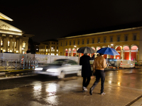 Two men walk on the streets of Munich, Bavaria, Germany, on December 8, 2024, with an umbrella during the Christmas season. (