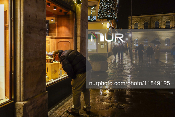 On a rainy evening in Munich, Bavaria, Germany, on December 8, 2024, during the Christmas season, the streets come alive with the glow of fe...