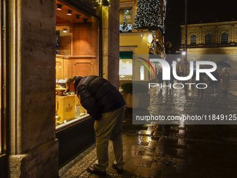 On a rainy evening in Munich, Bavaria, Germany, on December 8, 2024, during the Christmas season, the streets come alive with the glow of fe...