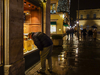 On a rainy evening in Munich, Bavaria, Germany, on December 8, 2024, during the Christmas season, the streets come alive with the glow of fe...