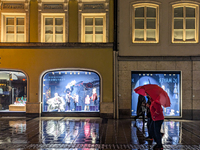 On a rainy evening in Munich, Bavaria, Germany, on December 8, 2024, during the Christmas season, the streets come alive with the glow of fe...