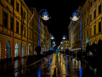 On a rainy evening in Munich, Bavaria, Germany, on December 8, 2024, during the Christmas season, the streets come alive with the glow of fe...