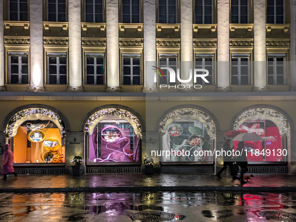 On a rainy evening in Munich, Bavaria, Germany, on December 8, 2024, during the Christmas season, the streets come alive with the glow of fe...