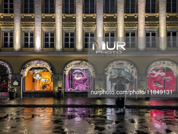 On a rainy evening in Munich, Bavaria, Germany, on December 8, 2024, during the Christmas season, the streets come alive with the glow of fe...