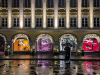 On a rainy evening in Munich, Bavaria, Germany, on December 8, 2024, during the Christmas season, the streets come alive with the glow of fe...