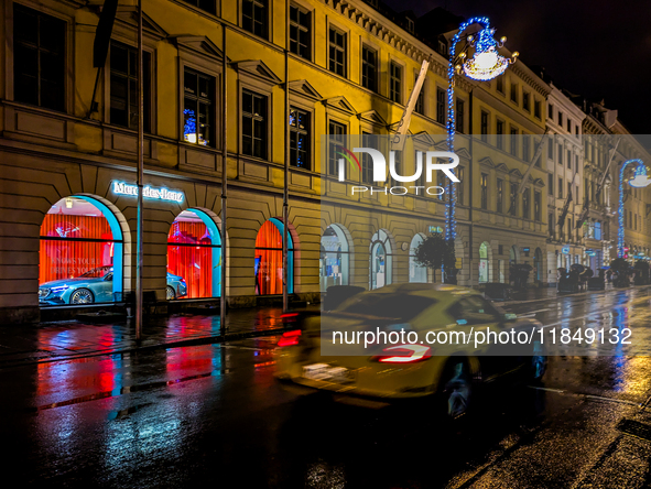 On a rainy evening in Munich, Bavaria, Germany, on December 8, 2024, during the Christmas season, the streets come alive with the glow of fe...