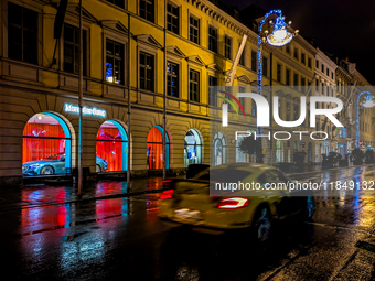 On a rainy evening in Munich, Bavaria, Germany, on December 8, 2024, during the Christmas season, the streets come alive with the glow of fe...